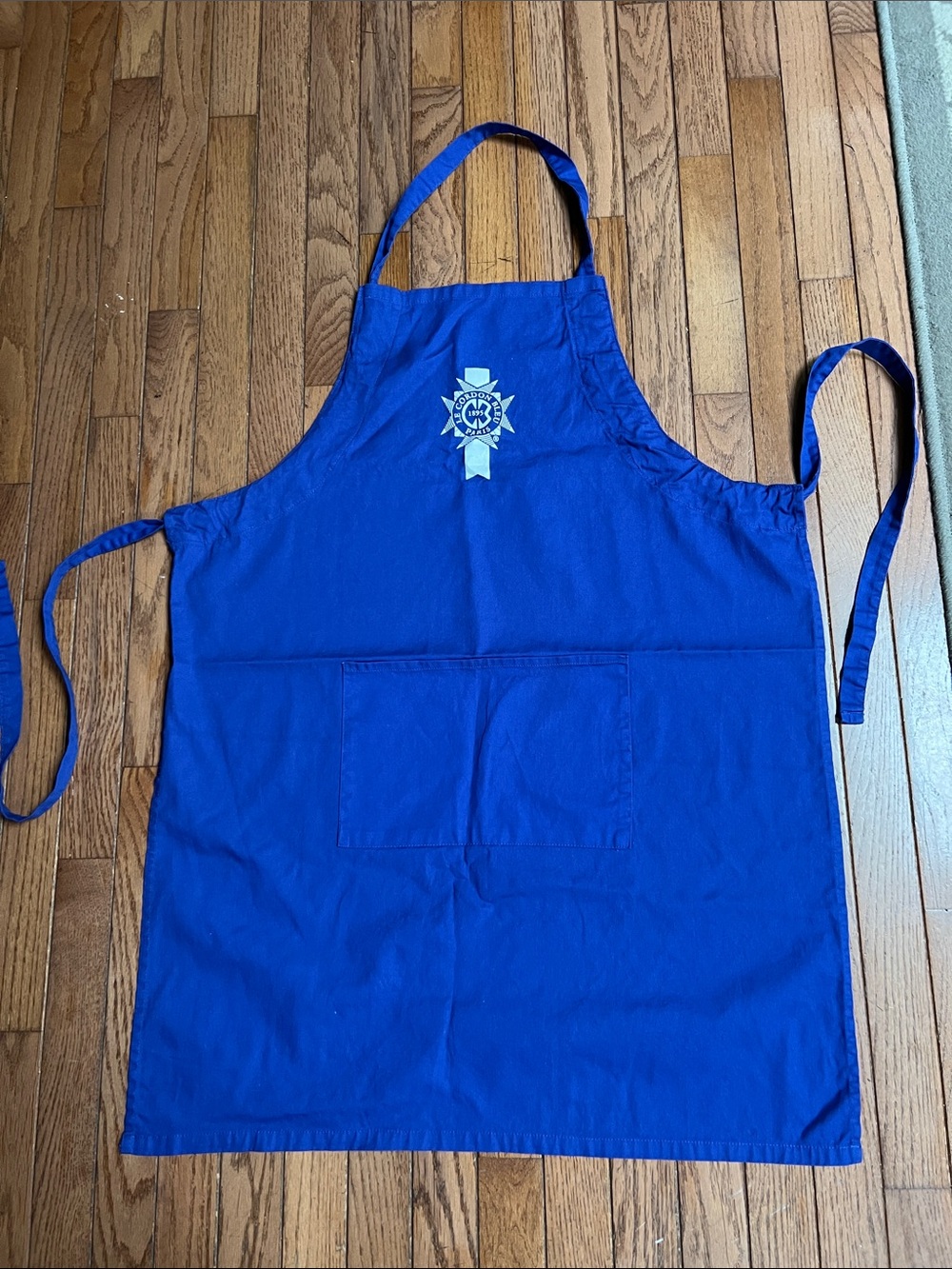 Le Cordon Bleu Paris bib apron featuring a white embroidered crest logo